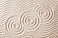 Zen garden pattern on sand as background, top view Royalty Free Stock Photo