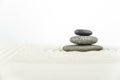 Zen garden. Pyramids of white and gray zen stones on the white sand with abstract wave drawings.