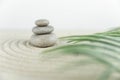 Zen garden. Pyramids of white and gray zen stones on the white sand with abstract wave drawings.