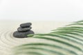 Zen garden. Pyramids of white and gray zen stones on the white sand with abstract wave drawings.