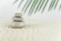 Zen garden. Pyramids of white and gray zen stones on the white sand with abstract wave drawings.