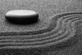 Zen garden stone on black sand with pattern Royalty Free Stock Photo