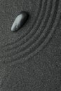 Zen garden stone on black sand with pattern, top view Royalty Free Stock Photo
