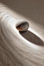 Zen garden tranquility with stone on rippled sand for meditation and mindfulness Royalty Free Stock Photo