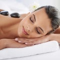 Zen, hot stone and woman with massage at spa for wellness, health and back treatment. Self care, cosmetic and young Royalty Free Stock Photo