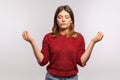 Zen, inner peace. Portrait of calm girl in shaggy sweater concentrating her mind, keeping hands up in mudra gesture