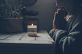 Zen like lifestyle meditation in front of a candle light praying for one woman at home. Green mood color style. Mental health Royalty Free Stock Photo