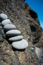 Zen like stack of stones leaning against black lava rocks on icelandic coast Royalty Free Stock Photo