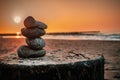 Zen-like stack of stones standing in harmony against the radiant sunset at the Baltic Sea Royalty Free Stock Photo