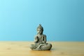 Zen, meditation and relaxation background. Buddha figurine on an empty calm blue background