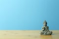 Zen, meditation and relaxation background. Buddha figurine on an empty calm blue background