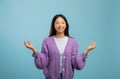 Zen. Peaceful asian lady meditating with closed eyes, practicing yoga and keeping hands in mudra gesture