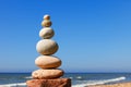 Zen pyramid of balanced stones on a background of the summer sea and blue sky Royalty Free Stock Photo