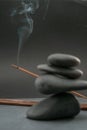 Zen spa basalt stones and green bamboo leaves and incense on black background. Royalty Free Stock Photo