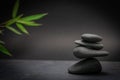 Zen spa basalt stones and green bamboo leaves on black background. Wellness and relaxation. Royalty Free Stock Photo