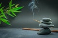 Zen spa basalt stones and green bamboo leaves and incense on black background. Royalty Free Stock Photo