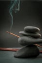 Zen spa basalt stones and green bamboo leaves and incense on black background. Royalty Free Stock Photo