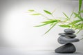 Zen spa basalt stones and green bamboo leaves on white background. Wellness and relaxation. Royalty Free Stock Photo