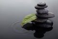 Zen stones in balanced pile and green leaf with water drops in water Royalty Free Stock Photo