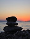 Silhouette of three zen rocks on the beach at suns Royalty Free Stock Photo