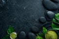 Zen stones and leaves with water drops. Spa background with spa accessories on a dark background. Top view. Free space Royalty Free Stock Photo