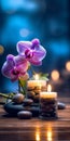 Zen stones, orchid flowers and aromatic candles spa arrangement on wooden table Royalty Free Stock Photo