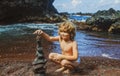 Kid with zen stones on sea beach, meditation, spa and harmony. Calm balance concept. Royalty Free Stock Photo