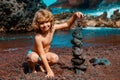Little boy zen stones on sea beach, meditation, spa and harmony. Calm balance concept. Royalty Free Stock Photo