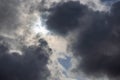 zenith pointed incoming storm cloudscape with heavy clouds and sun between them, full-frame real life photo