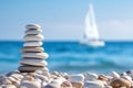 Zenith of Serenity: Balanced Stones on the Shoreline with a Distant Sailboat Royalty Free Stock Photo