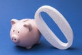 Zero and piggy bank on a blue background. Concept on the topic of zeroing deposits and savings Royalty Free Stock Photo