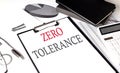 ZERO TOLERANCE text on paper clipboard with chart and notebook on withe background Royalty Free Stock Photo