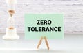 ZERO TOLERANCE text on a paper clipboard with chart and notebook on withe background Royalty Free Stock Photo