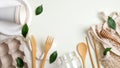 Zero waste bamboo cutlery set, reusable shopping bag, glass jar, egg carton, paper utensils and green leaves. Flat lay, top view.