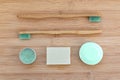 Zero waste bathroom basics. Bamboo toothbrushes, solid toothpaste in metal tin, solid shampoo and soap on wood. Plasti