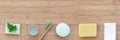 Zero waste bathroom web banner with copy space. Bamboo toothbrushes, solid toothpaste, solid shampoo and soap on wood.