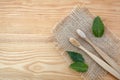 Zero waste concept. Bamboo toothbrush on wooden background with green mint leaf. Plastic free essentials, teeth care.