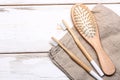 Zero waste concept with bathroom accessories on white wooden background. wooden hairbrush and two bamboo toothbrushes on a linen Royalty Free Stock Photo