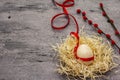 Zero waste Easter concept. Wooden egg, bird`s nest, satin ribbon, red willow seals. No plastic, eco trend. Gray concrete Royalty Free Stock Photo