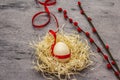 Zero waste Easter concept. Wooden egg, bird`s nest, satin ribbon, red willow seals. No plastic, eco trend. Gray concrete Royalty Free Stock Photo