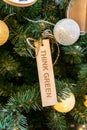 Zero waste eco-friendly christmas tree with wooden toy and text Think green. Environmental concept of new year decoration