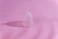 Zero waste eco-friendly menstrual cup on pink background with creative shadows Royalty Free Stock Photo