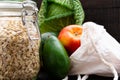 Zero waste grocery shopping. Package-free food on dark wooden table with texture. Fresh vegetables and fruits in Eco cotton bags. Royalty Free Stock Photo