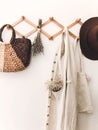 Zero waste home concept. Sustainable lifestyle. Stylish wooden hanger with straw bag, linen tote bag, brown hat and linen cloth.