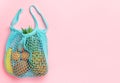 Zero waste lifestyle. Various fruits in reusable shopping bag on pink background. Top view, copy space Royalty Free Stock Photo