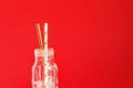 Zero waste. Paper recycable drinking cocktail party straws in glass vintage bottle on red background Royalty Free Stock Photo