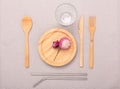 Zero waste, plastic free concept. Wooden plate, glass cup, Set of bamboo cutlery. Flat lay on textile linen background
