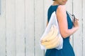 Zero waste shopping concept. No single use plastic. Woman holding reusable recycled mesh produce bag with bananas Royalty Free Stock Photo