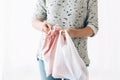 Zero Waste shopping concept. Woman holding in one hand groceries in reusable eco bag and in other vegetables in plastic Royalty Free Stock Photo