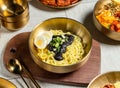 Zha Jiang fried noodles with boiled eggs, spring onion, spoon and chopsticks served in golden dish isolated on wooden board side Royalty Free Stock Photo